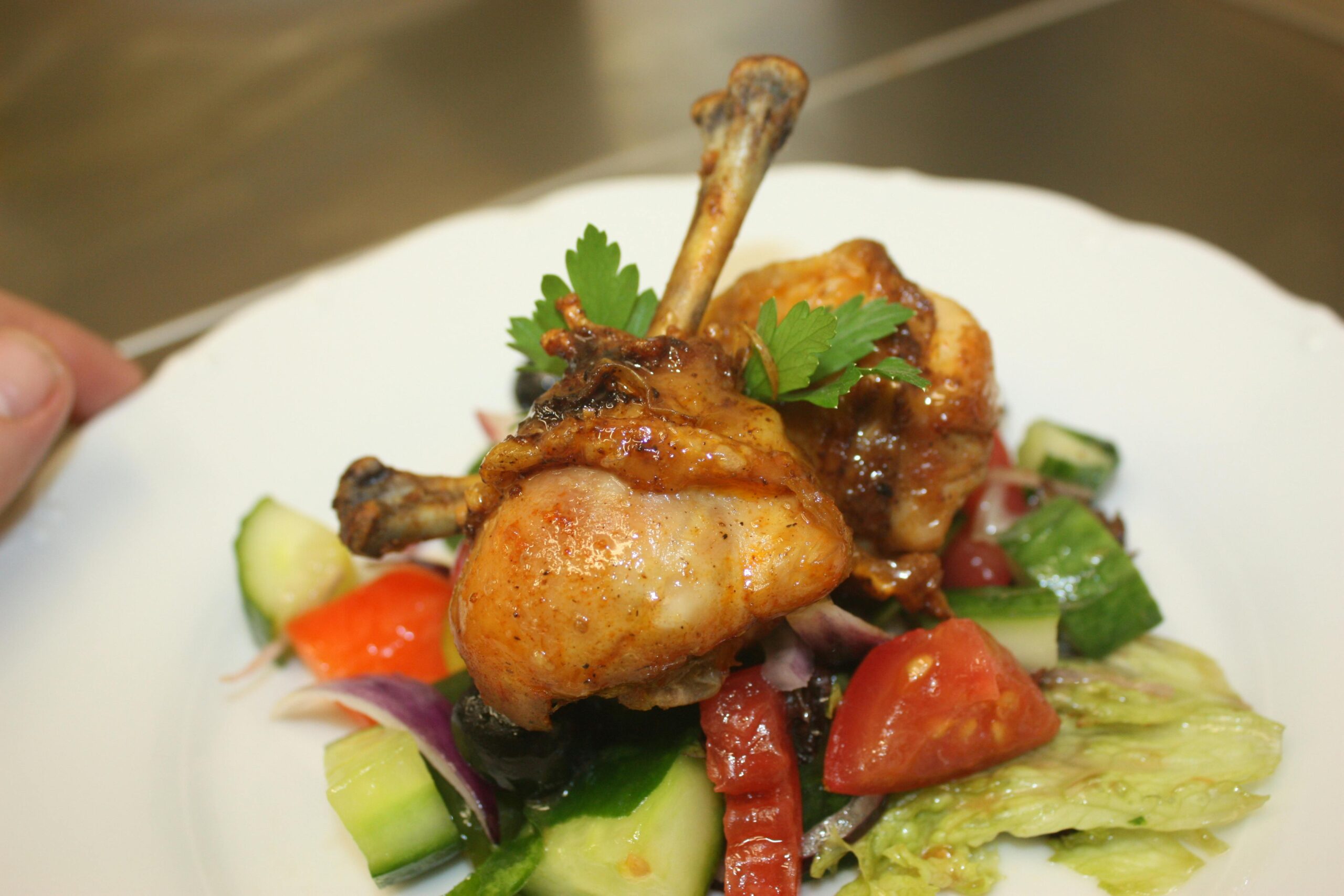 Close-up of a delicious chicken drumstick meal, garnished with fresh veggies.